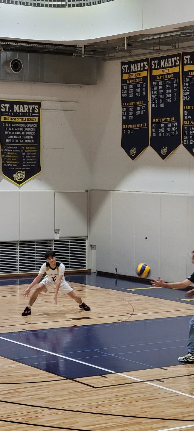 Playing volleyball on an indoor court.